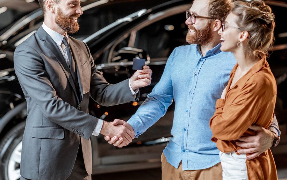 Couple at dealership greeting sales staff