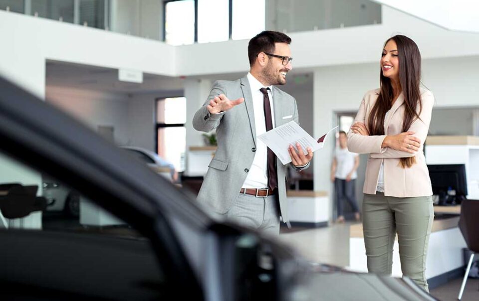 Professional salesperson selling cars at dealership