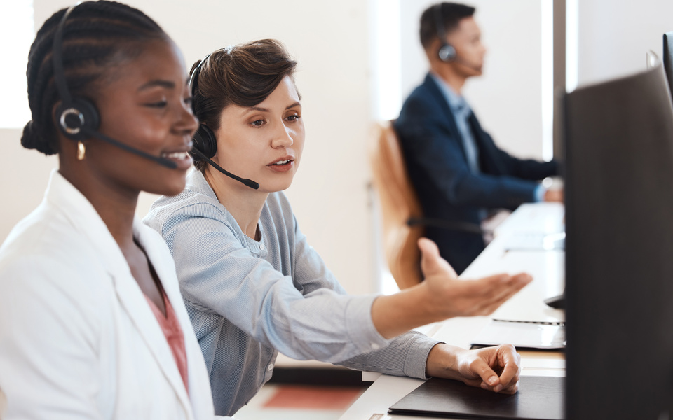 Black woman, manager and training in office in call center for customer service, headset and online faq. Female agent, headphones and staff help in telemarketing agency for consultation and crm coach