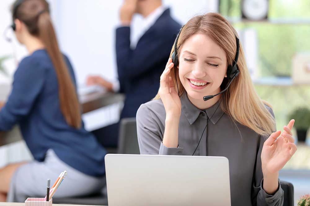 Young female receptionist with headset in office