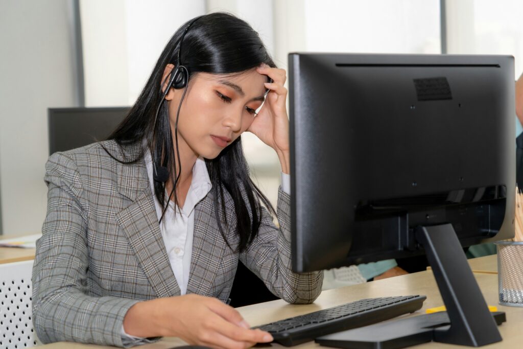 burnt out bdc agent female sitting at desktop with headset