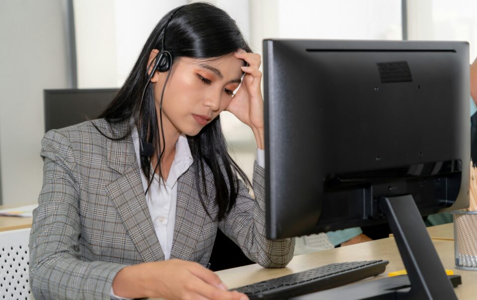 burnt out bdc agent female sitting at desktop with headset