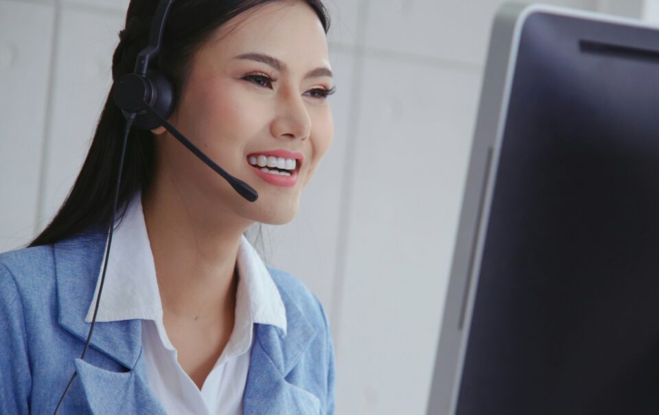bdc agent female with headset on smiling at dashboard