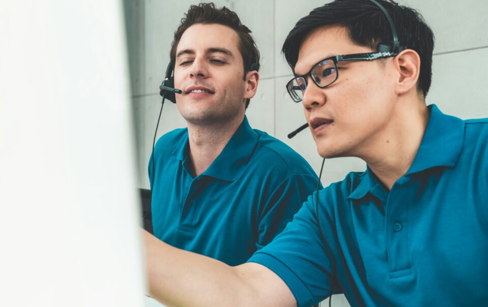 two male bdc agents working in collaboration at their computer