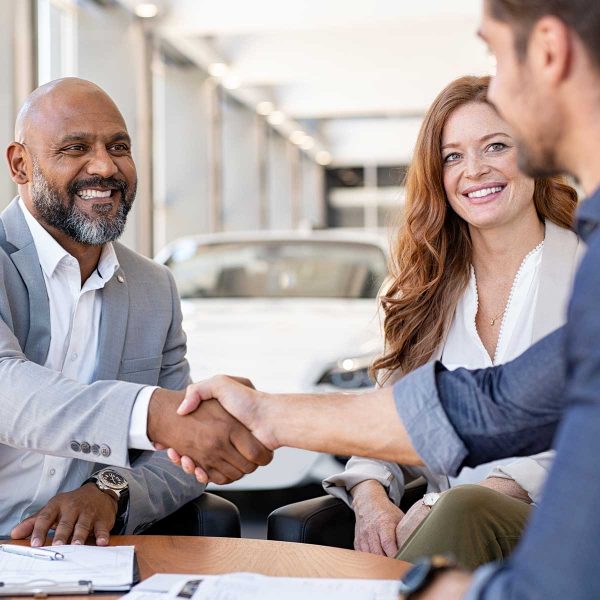 customer is shaking hand of dealership personnel